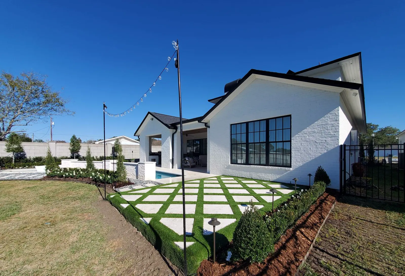 Front yard install with fresh turf, a new mulch bed, and a paver walk