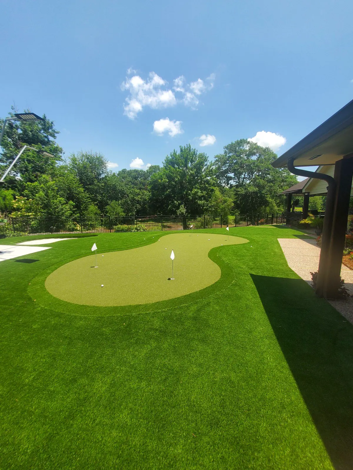 Pool edge with light pavers and a strip of artificial turf